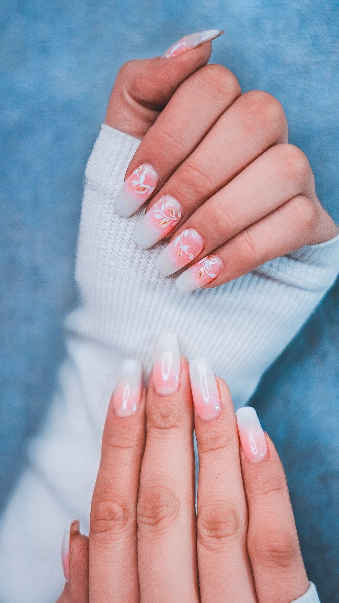 Unhas decoradas em degradê rosa com detalhes florais